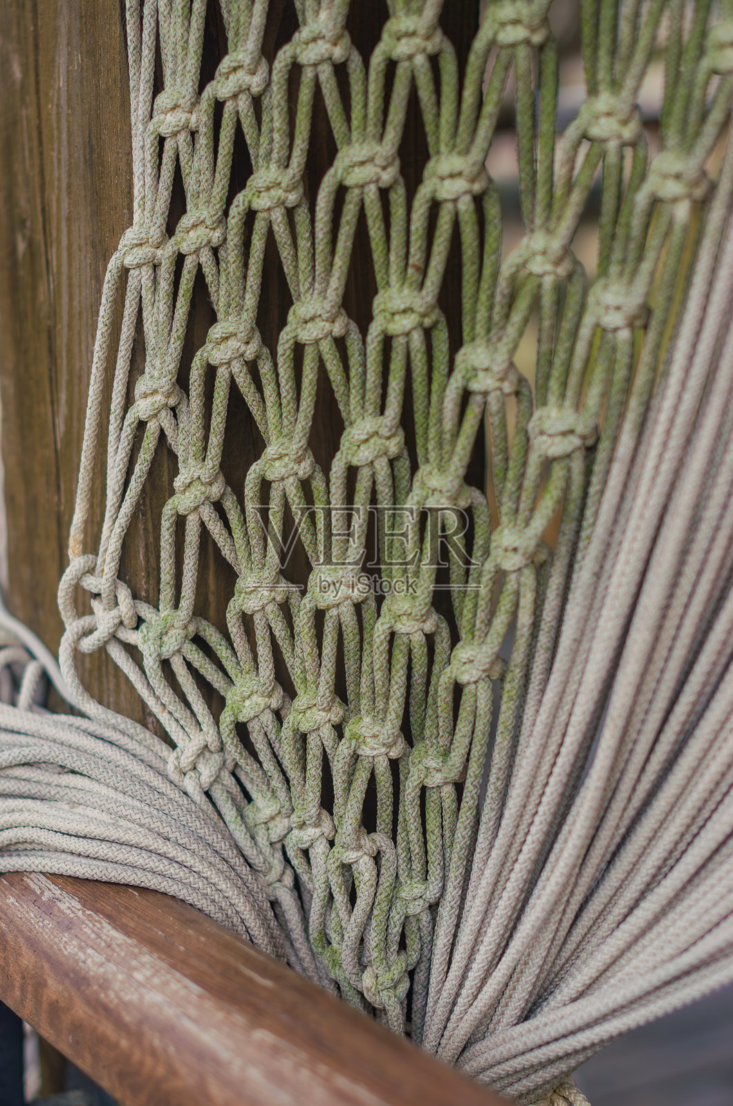 特写镜头展示了风化的绳索窗帘，突显出复杂的结绳工艺和纹理。照片摄影图片
