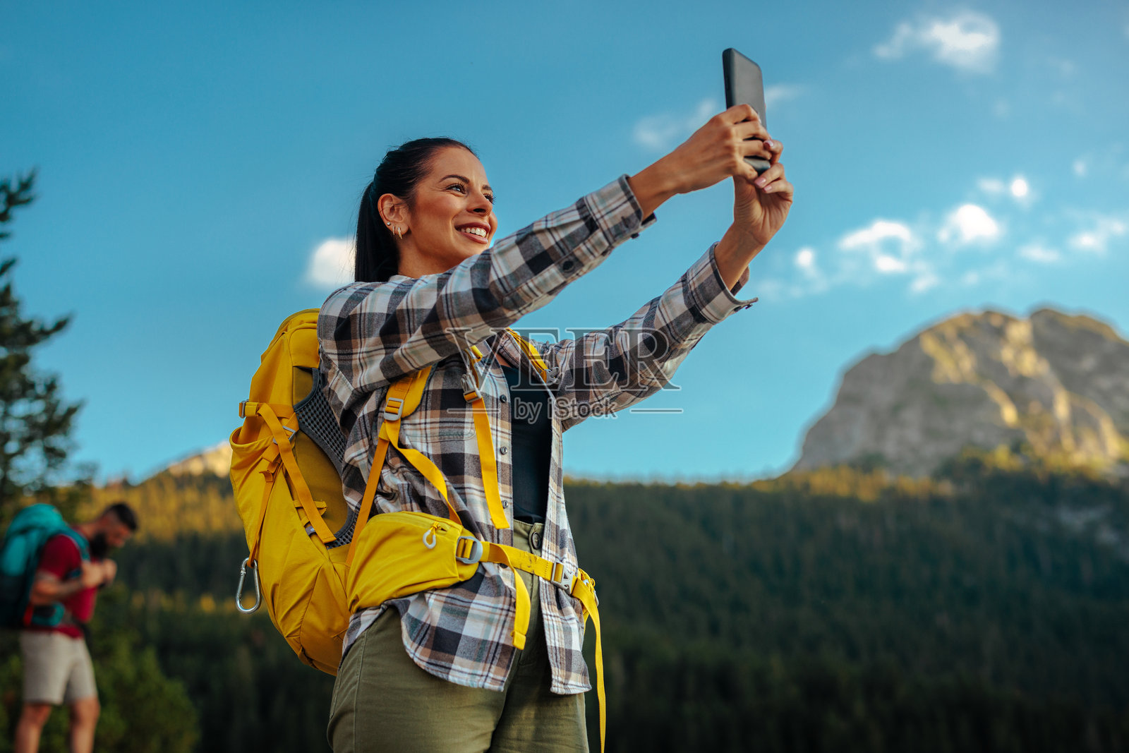 微笑的女性徒步旅行者正在自拍照片摄影图片