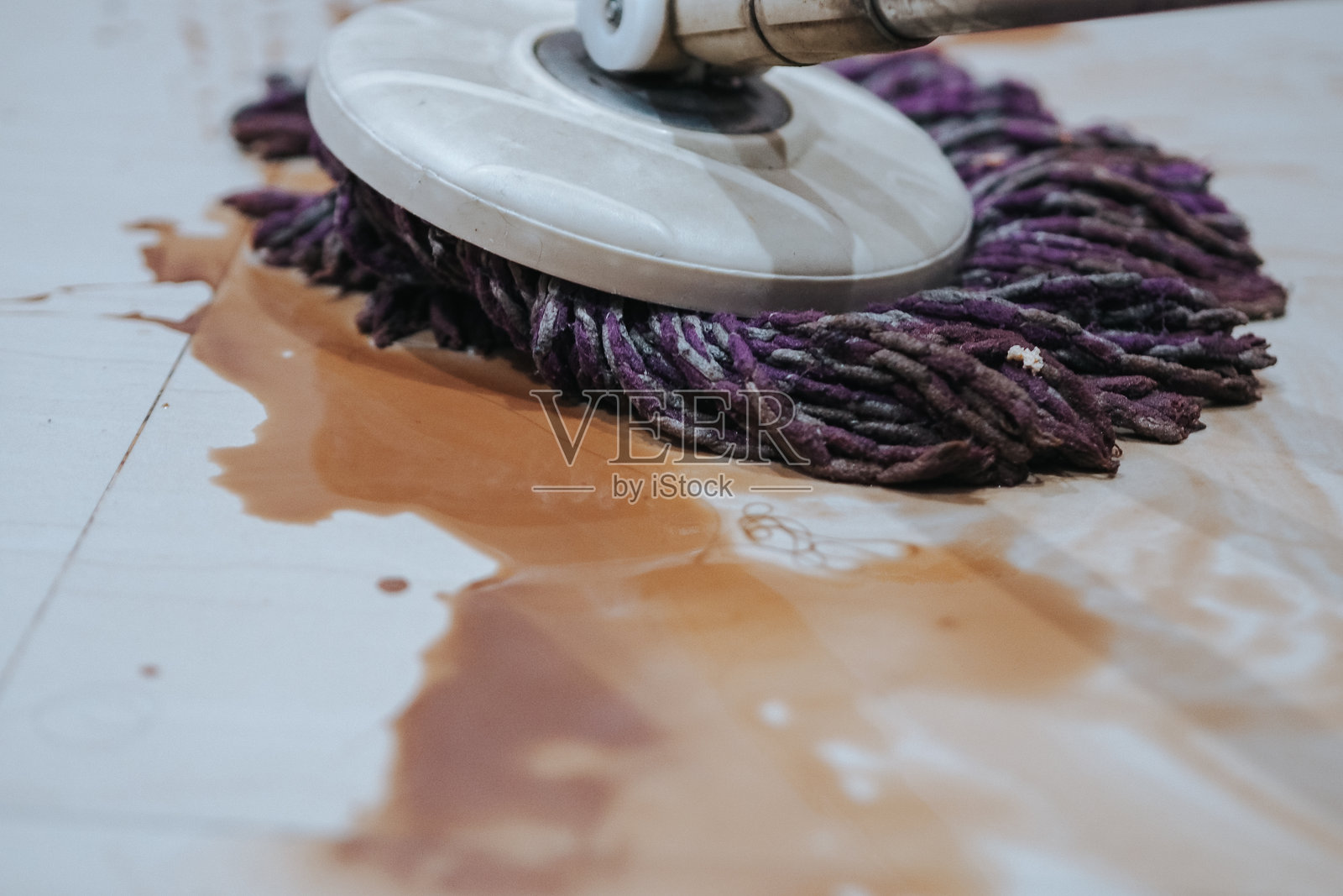 地板上洒落的巧克力饮料用拖把清理干净照片摄影图片