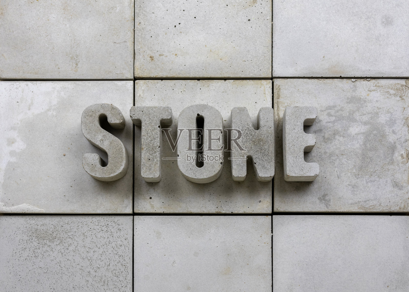 混凝土背景上用混凝土字母拼写的“STONE”，有良好的留白空间照片摄影图片