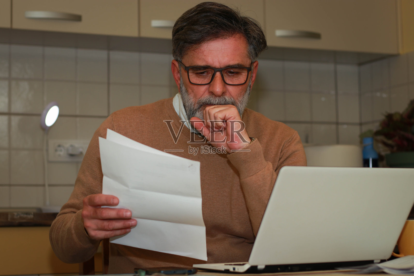 在家中为账单在线支付的老年男性照片摄影图片