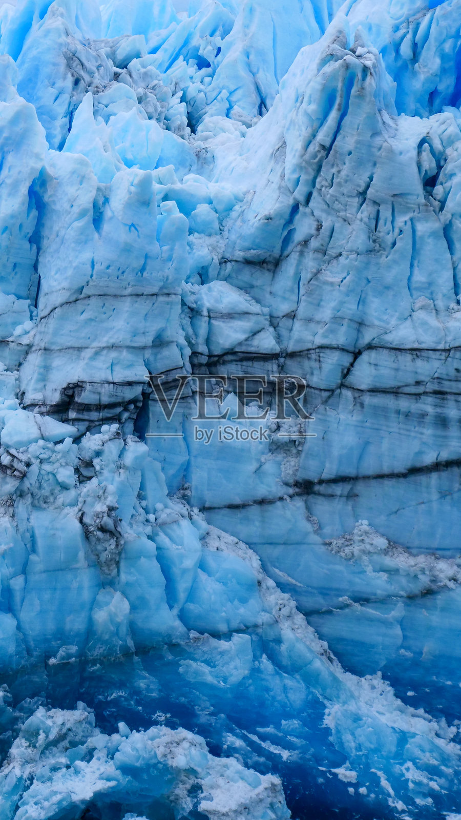 在阿根廷洛斯冰川国家公园的佩里托莫雷诺冰川蓝色冰缘上可见黑色线条。照片摄影图片