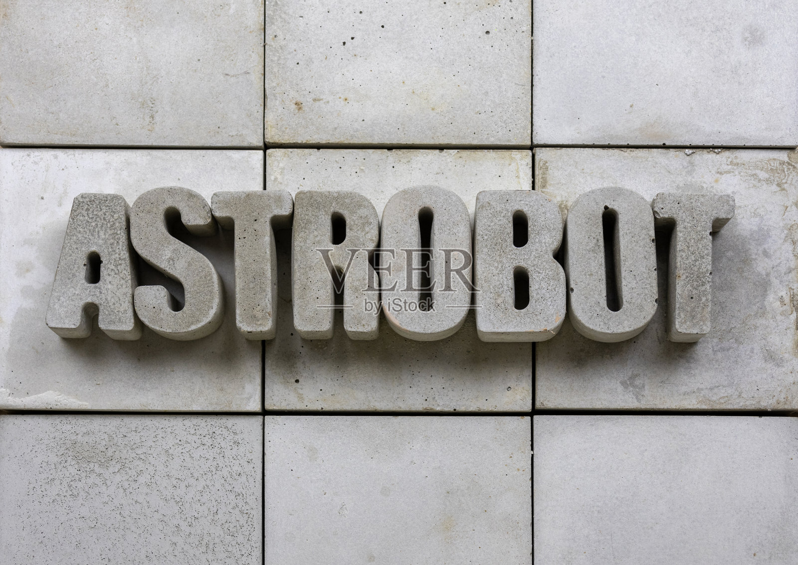 在混凝土瓷砖背景上用混凝土字母写的“astrobot”，有良好的留白空间。照片摄影图片