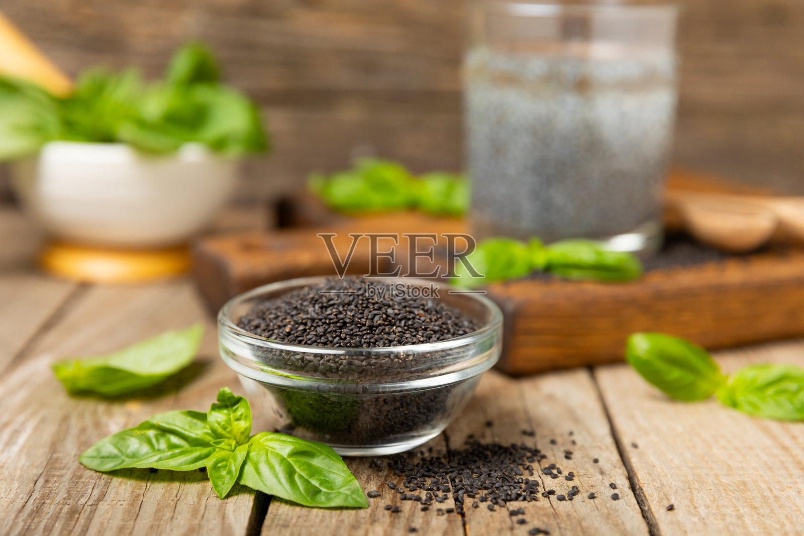 有纹理的木质背景上的罗勒种子。特写。超级食品。Ocimum basilicum。有机罗勒种子。selasih。留白空间。照片摄影图片