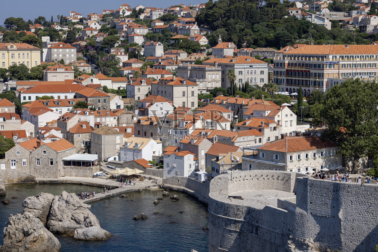 克罗地亚杜布罗夫尼克老城附近的亚得里亚海小湾西港，石码头旁边的古老城墙。照片摄影图片