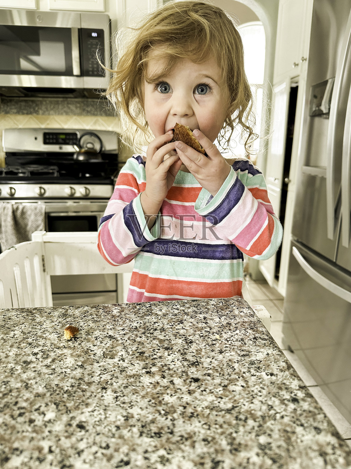 幼儿在厨房的学习塔上吃东西和做饭照片摄影图片