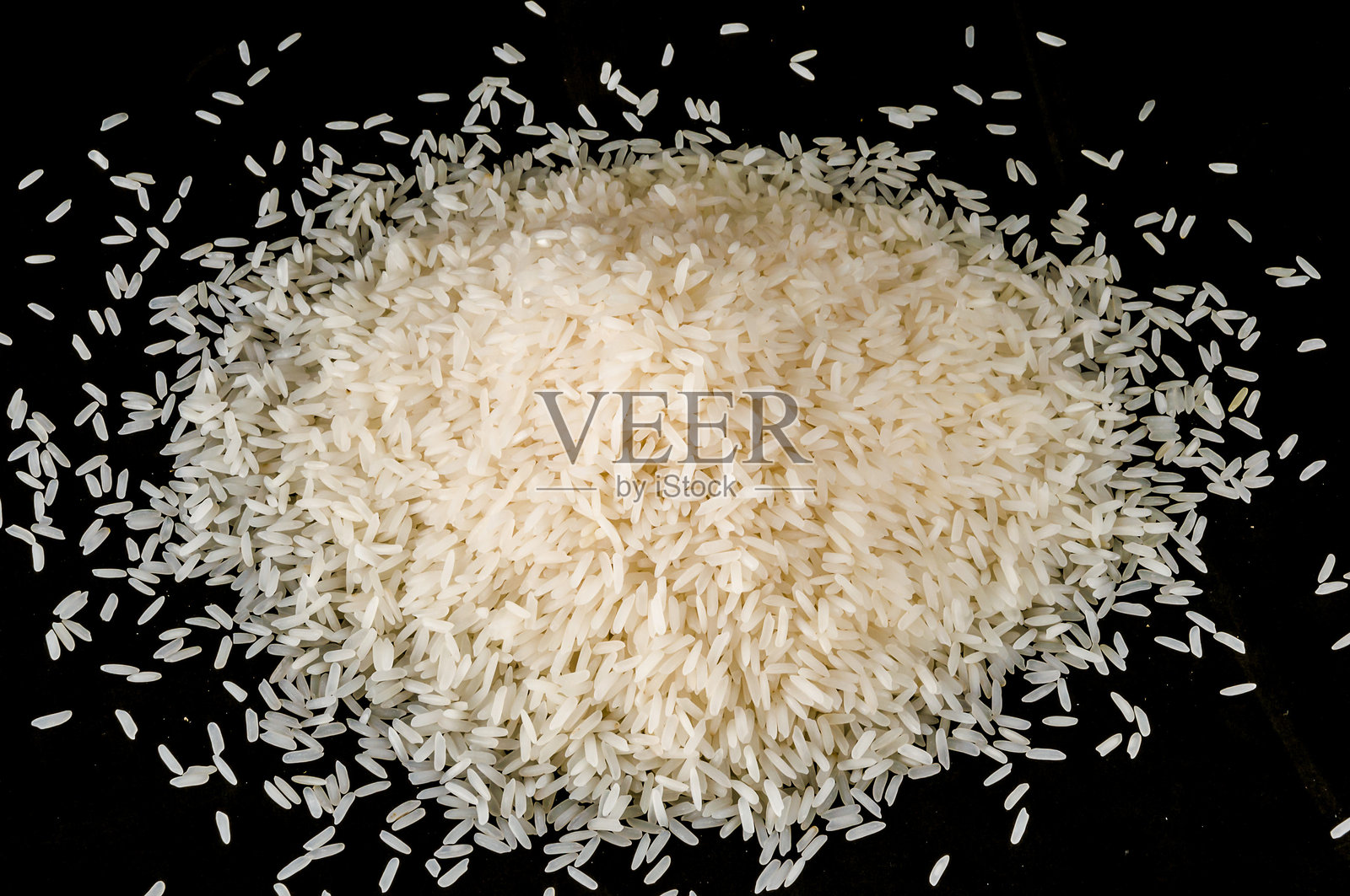 一堆白米放在黑色表面上照片摄影图片
