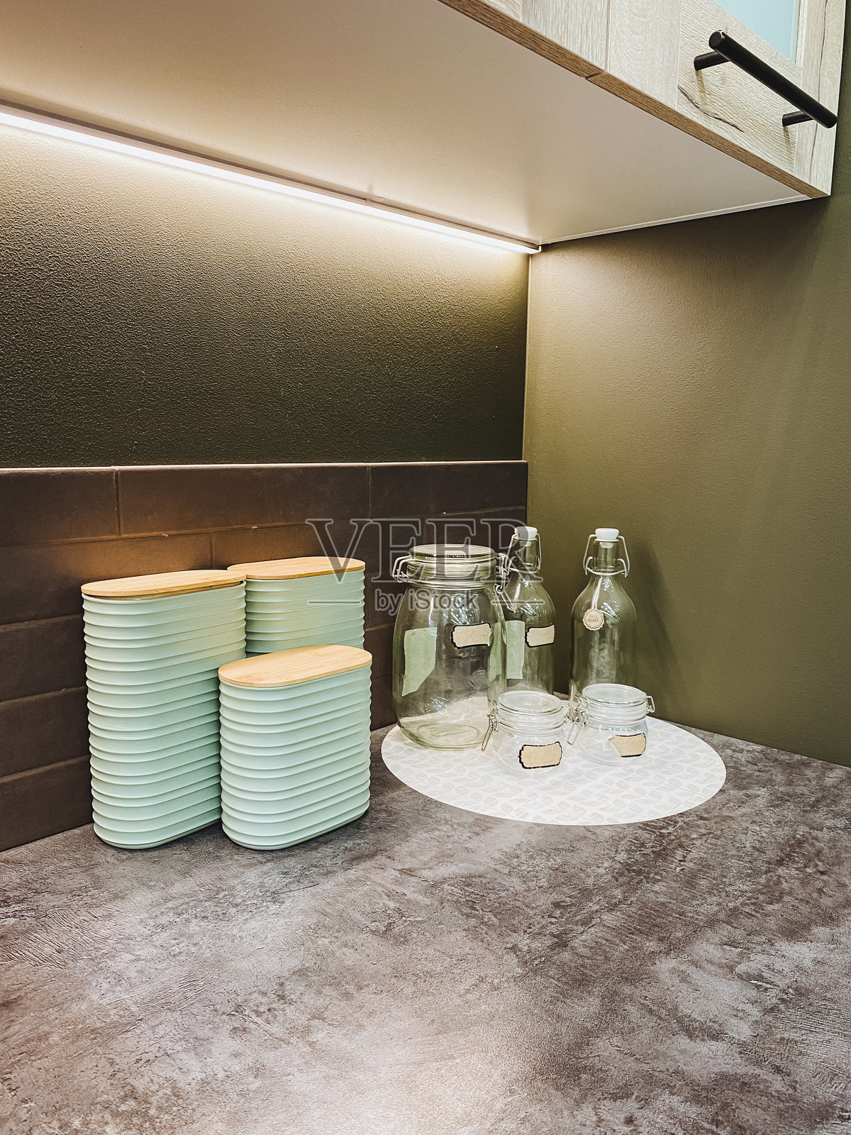 这是一个美丽时尚的厨房台面布置，优雅的玻璃罐与薄荷绿色的餐具相伴，增添了魅力。照片摄影图片