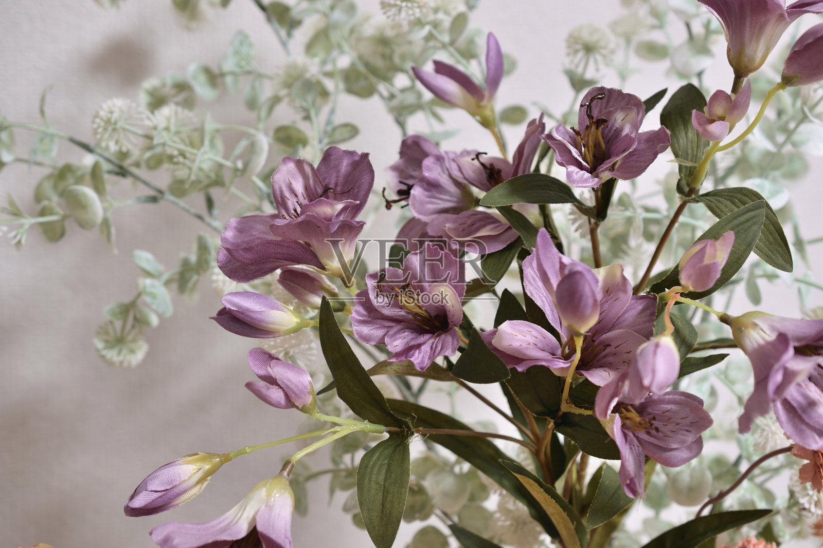 室内拍摄的花卉照片，展示了色彩缤纷的花束摆放在花瓶中。照片摄影图片