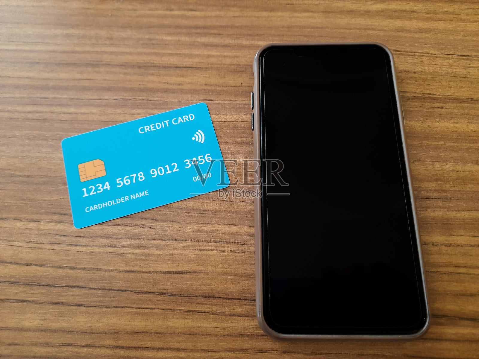 Blue Credit Card with Smartphone on Wooden Table照片摄影图片