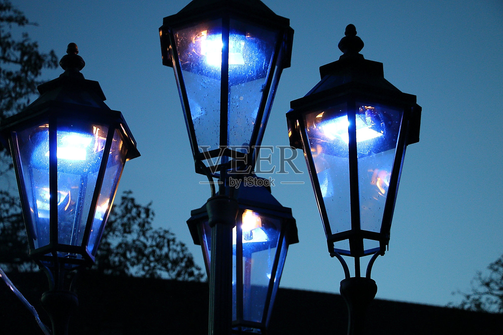 低角度视图的街灯在蓝天映衬下发光照片摄影图片