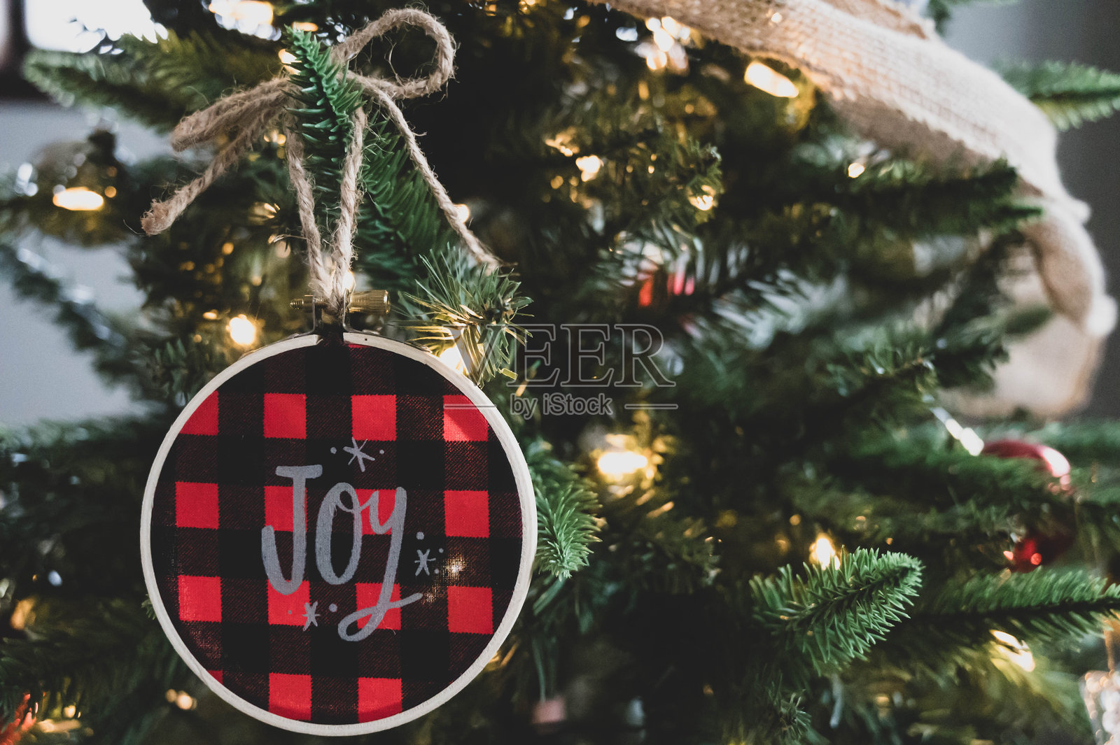 点亮的圣诞树特写，挂着“快乐”装饰和麻布装饰照片摄影图片