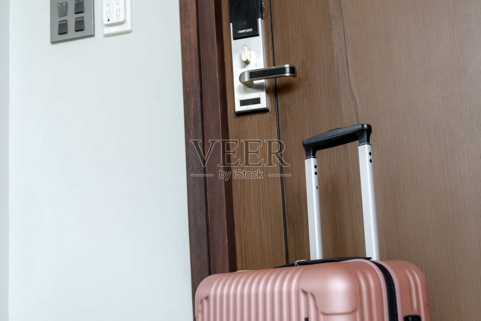 一个放在酒店房间门前的行李箱照片摄影图片
