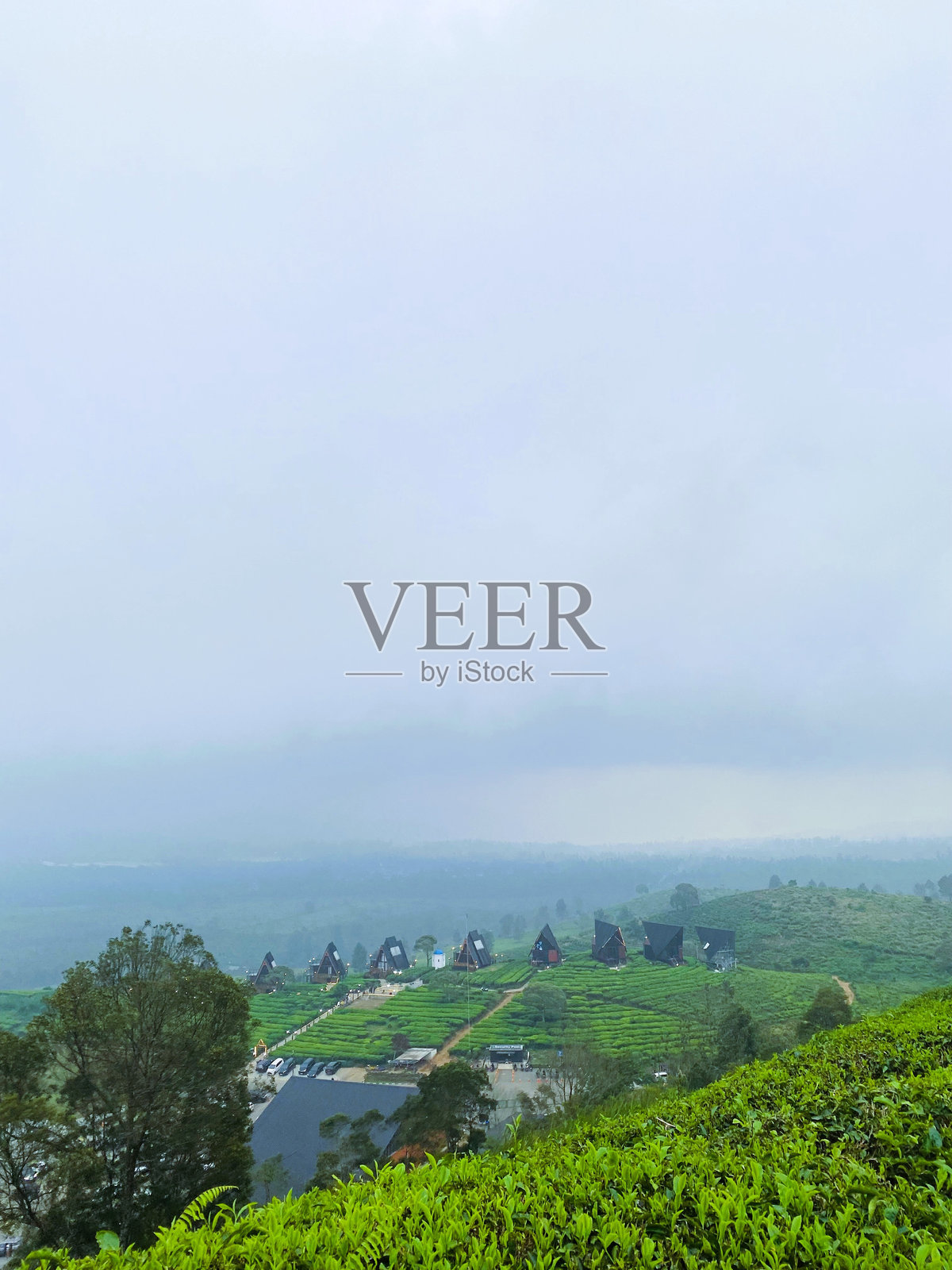 浓密的云层笼罩着郁郁葱葱的山丘照片摄影图片