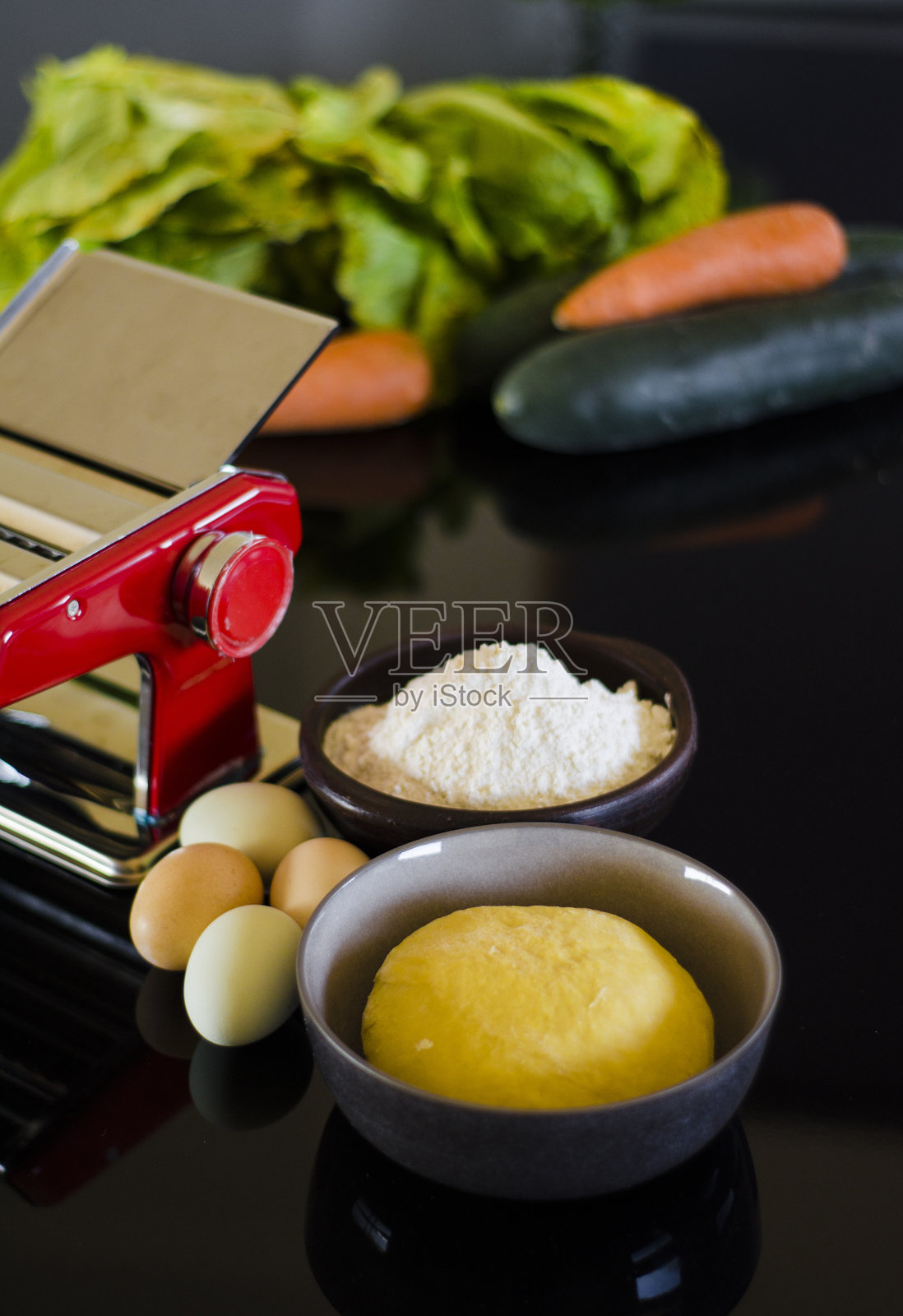 自制的新鲜意大利面和厨房桌上的机器照片摄影图片