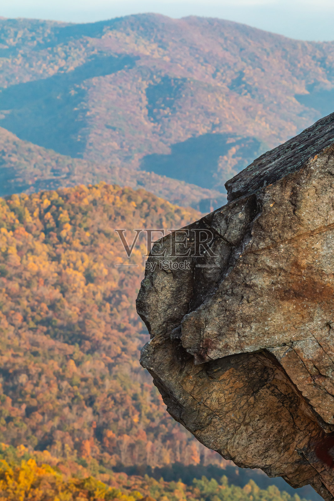 锯齿状岩石在秋季山脉的色彩中突出。照片摄影图片