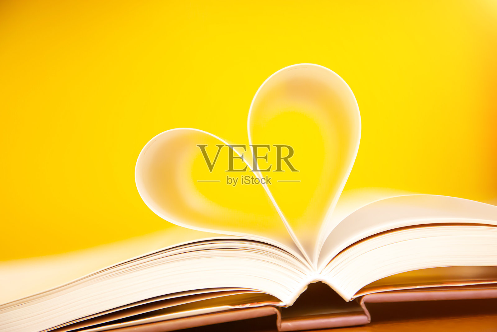 图书馆桌子上心形的书籍特写，体现了热爱阅读的生活方式和二月情人节的概念。照片摄影图片