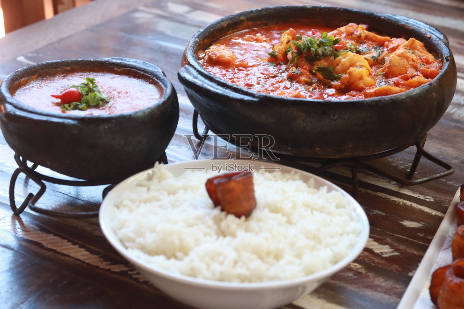 巴西鱼虾炖菜，放在桌子上的摩奎卡。来自埃斯皮里图桑托的摩奎卡，盛在陶罐中。照片摄影图片