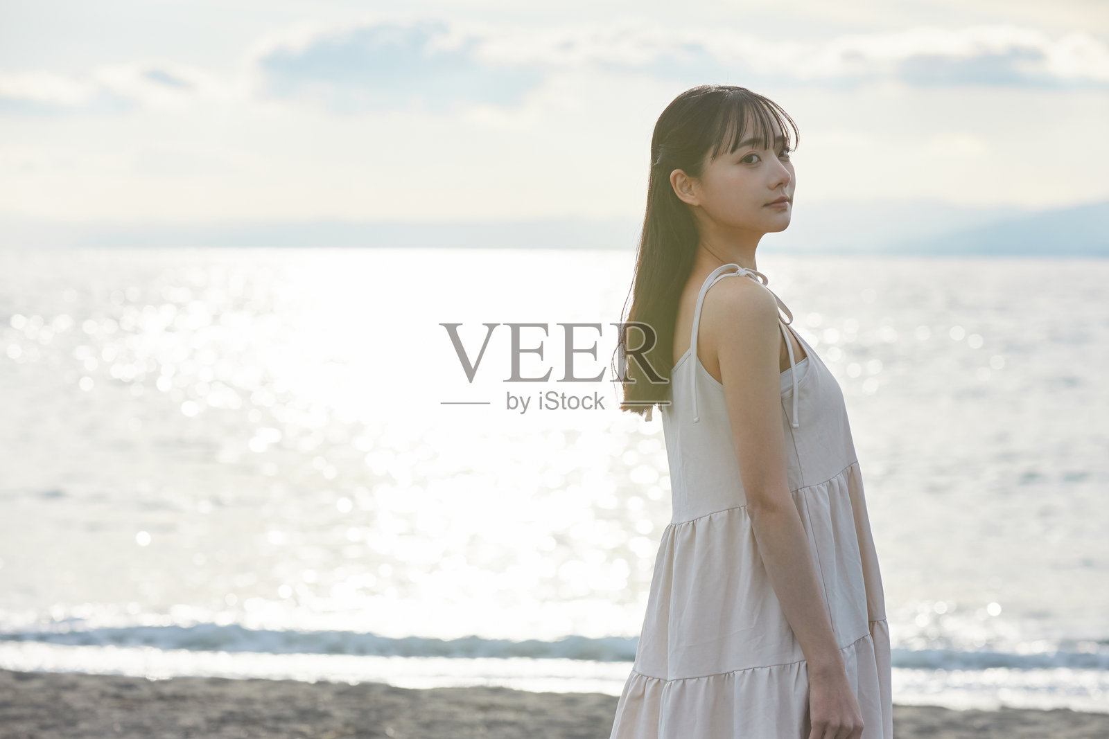 年轻的亚洲女性在海滩上漫步照片摄影图片