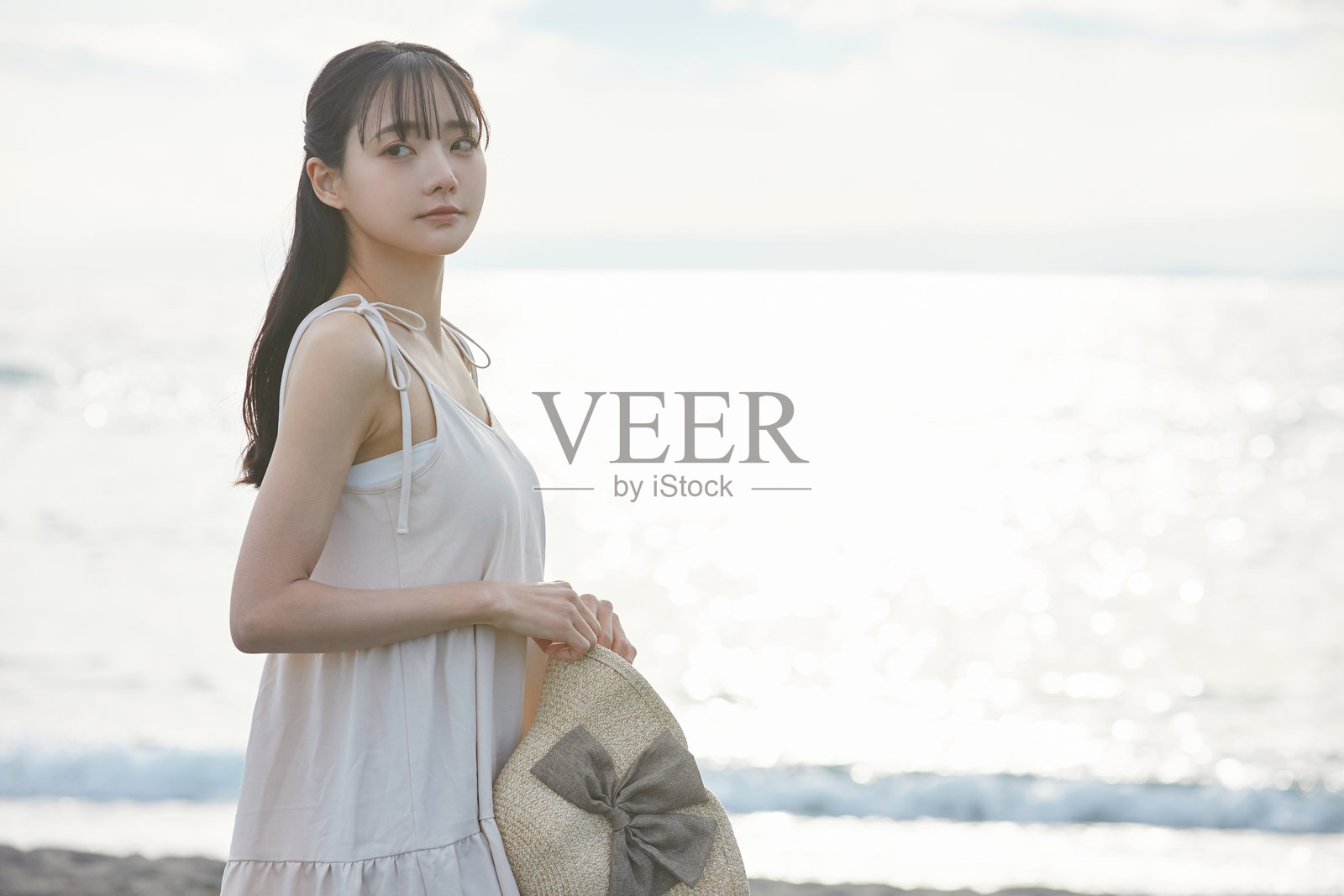 年轻的亚洲女性在海滩上漫步照片摄影图片