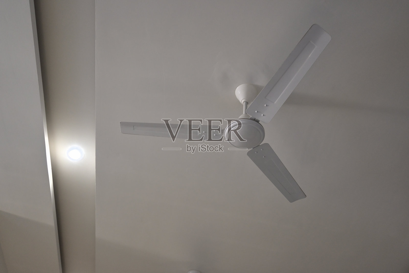 现代房间里的白色吊扇。照片摄影图片