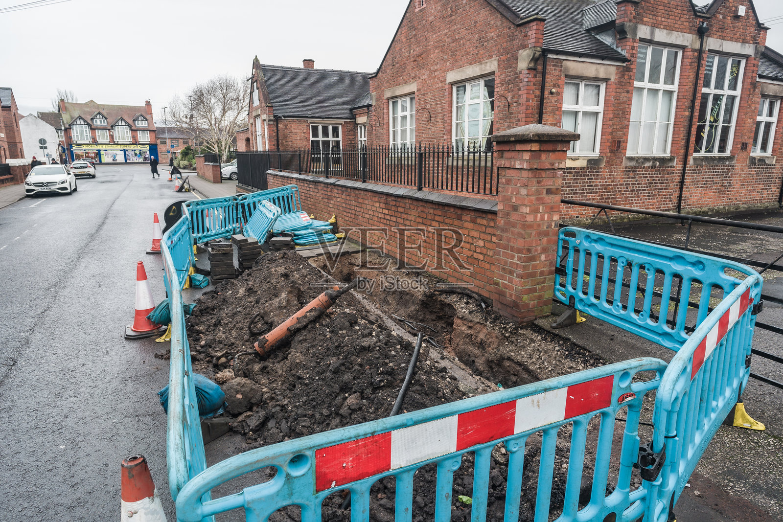 南特维奇的一条街道,路面施工暴露了地下管道。照片摄影图片