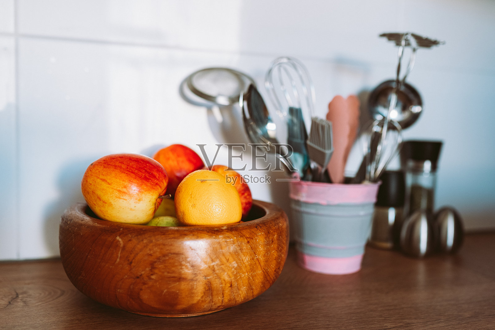 铁制装饰桶中的厨房用具或烹饪工具，放在厨房木质台面上。厨房用具集合照片摄影图片
