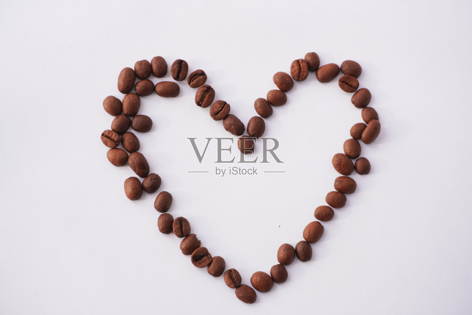 咖啡豆在白色背景上排列成心形照片摄影图片