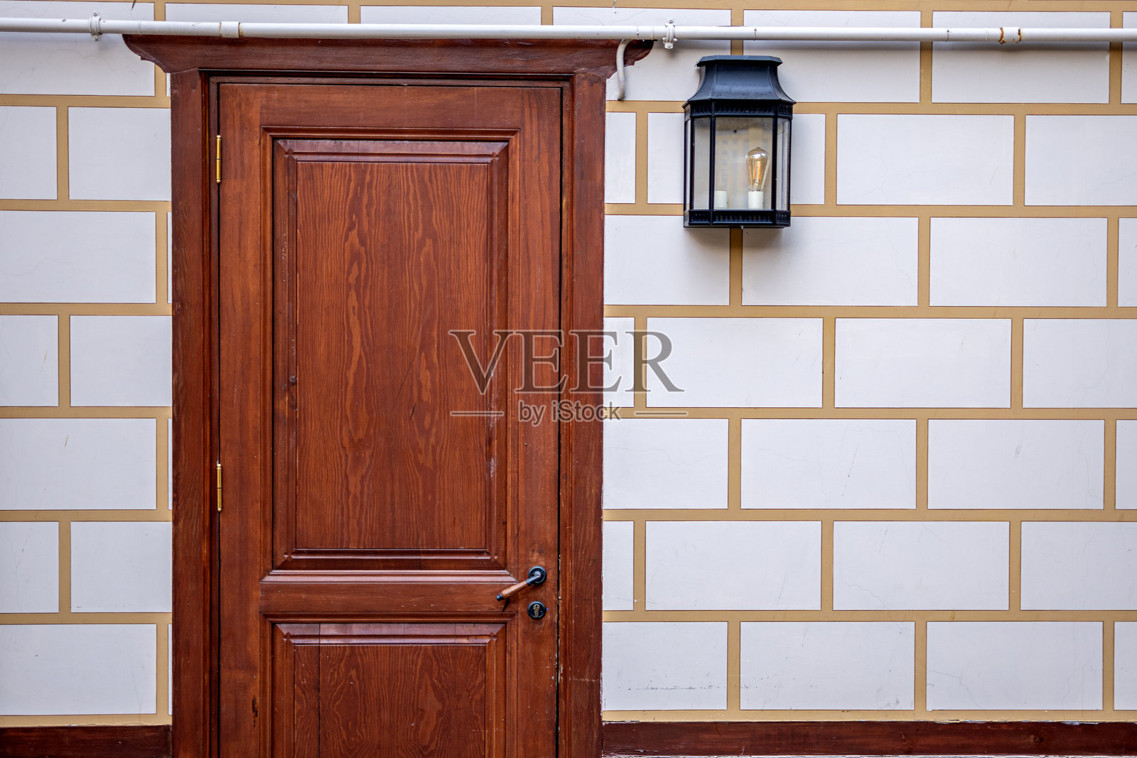 建筑外立面的特写，配有复古风格的棕色木门。质感石砖和一扇古老的木门。照片摄影图片