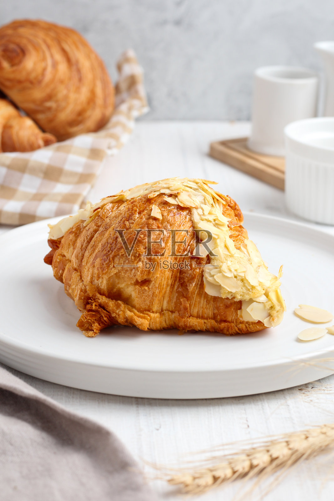 白盘上的杏仁可颂 pastry。照片摄影图片