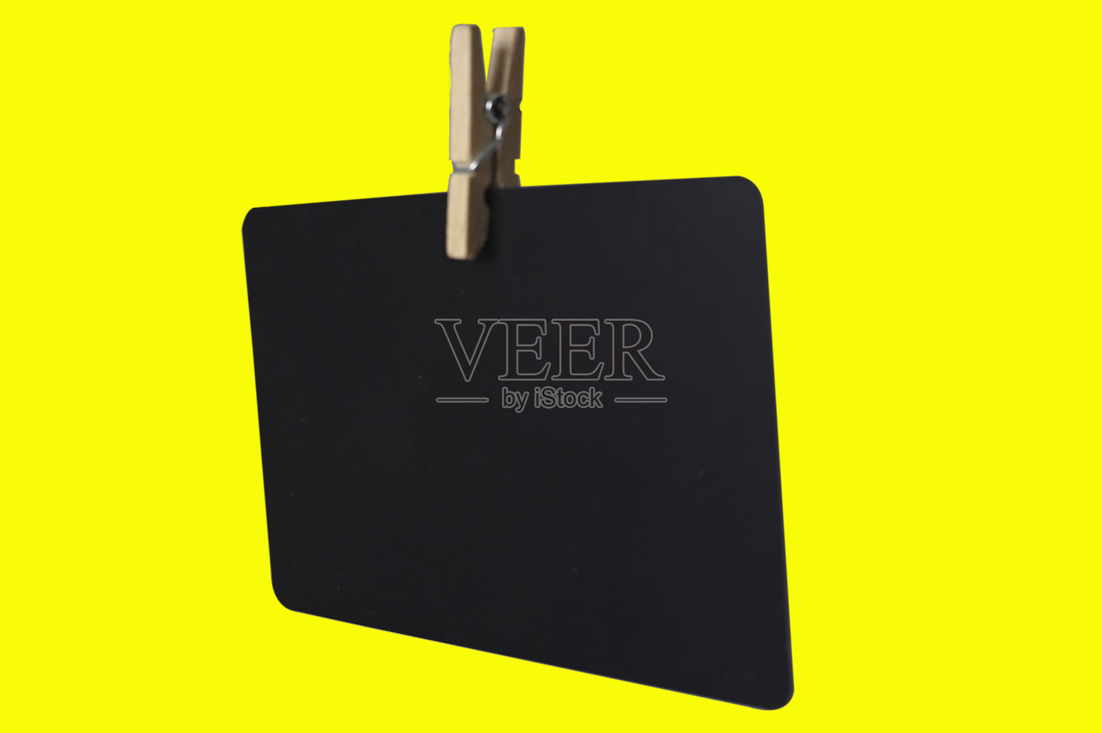 黑色卡片悬挂在夹子上，背景是办公记笔记用品，适合用于文本、笔记或公告。照片摄影图片