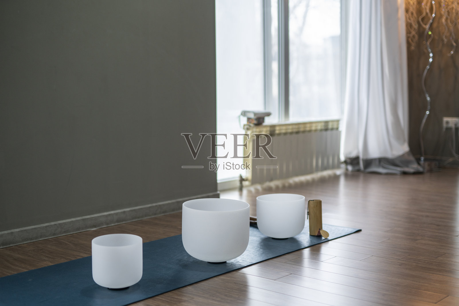 水晶石英唱碗放置在瑜伽工作室的地板上。照片摄影图片