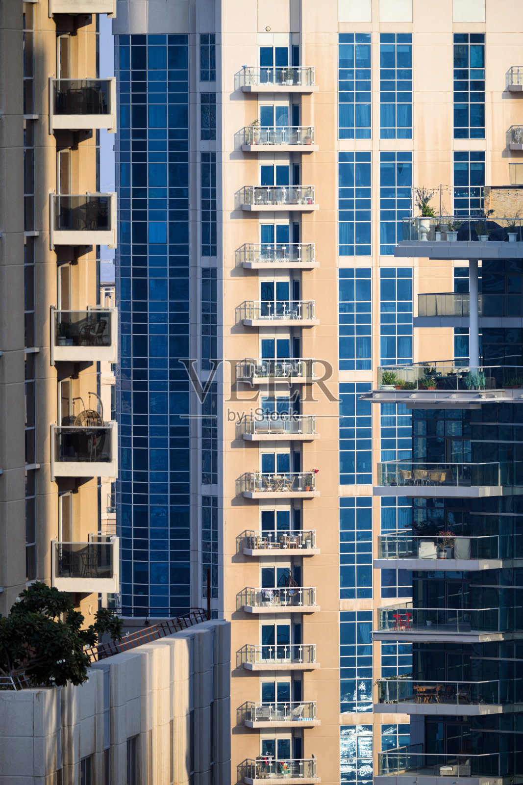 城市高层住宅建筑上的阳台，背景有蓝色玻璃细节照片摄影图片