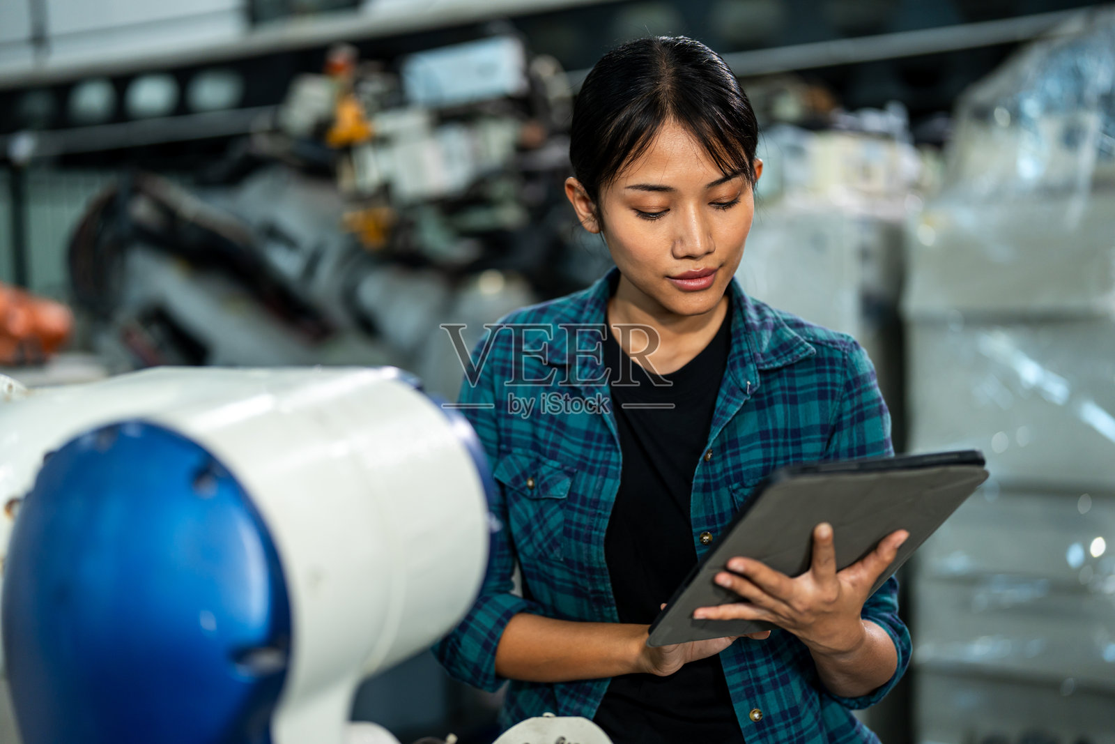 女性技术人员正在用平板电脑分析机器人设备照片摄影图片