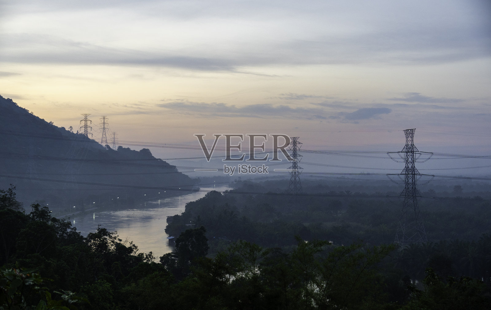 日出时分，河流上空，前景是电力线，背景是山脉风景。照片摄影图片