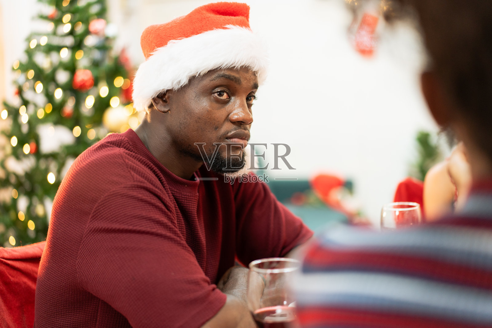 非洲家庭或朋友在家中庆祝圣诞派对时愉快地交谈。人们在活动中穿着圣诞服装。照片摄影图片