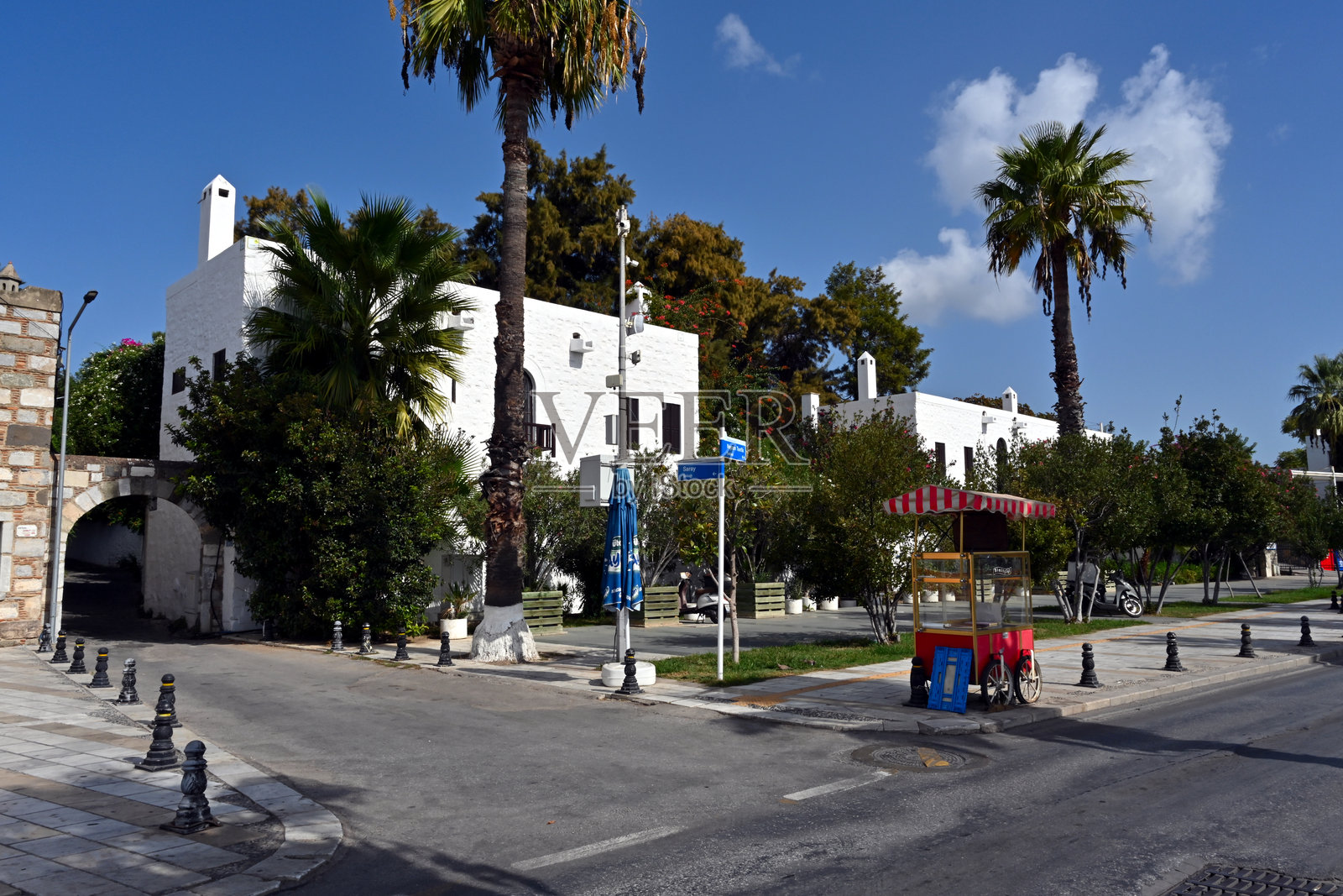 博德鲁姆街头的空面包售卖手推车，周围是典型建筑和树木灌木环绕。照片摄影图片