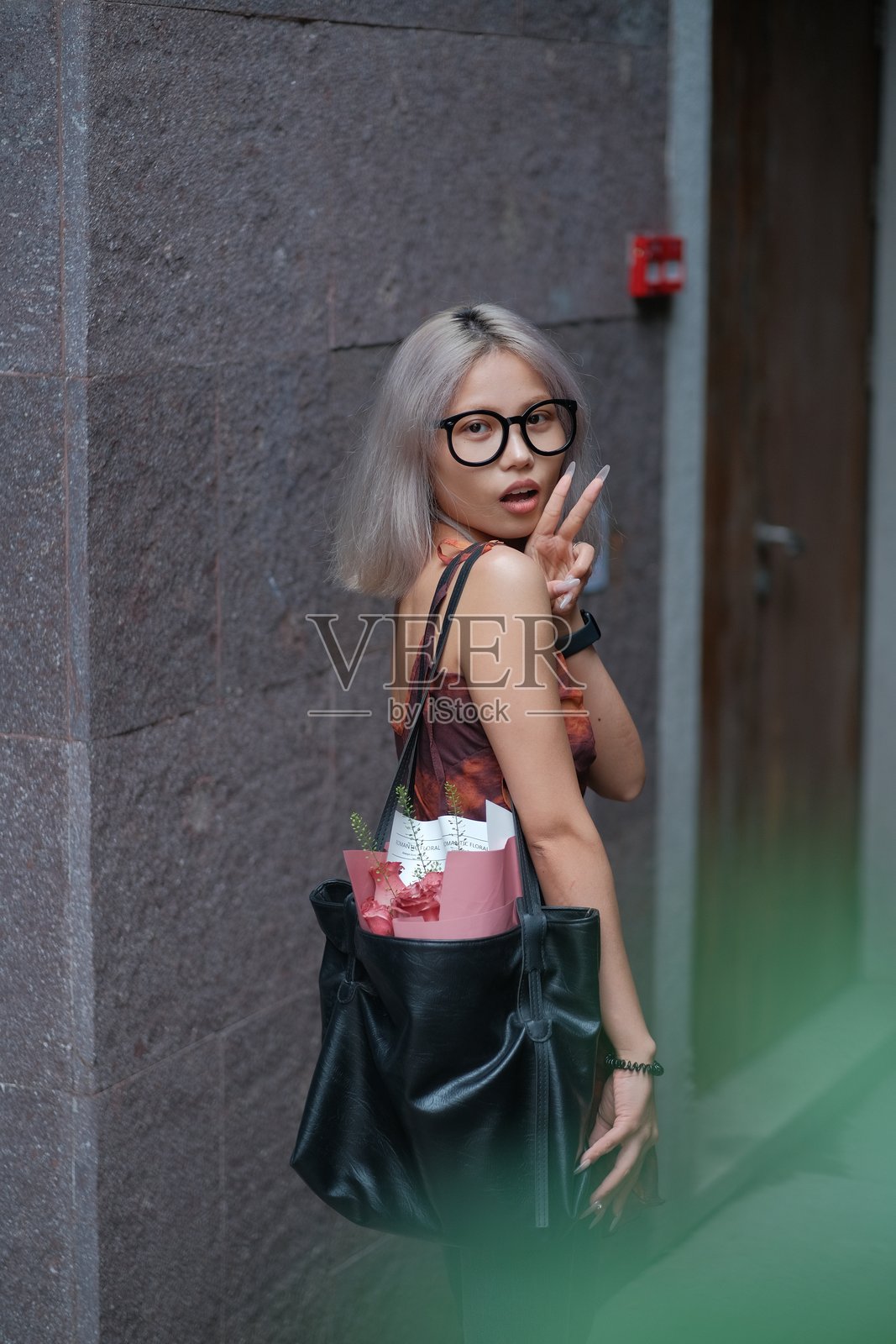 年轻女性靠在墙边的肖像照片摄影图片