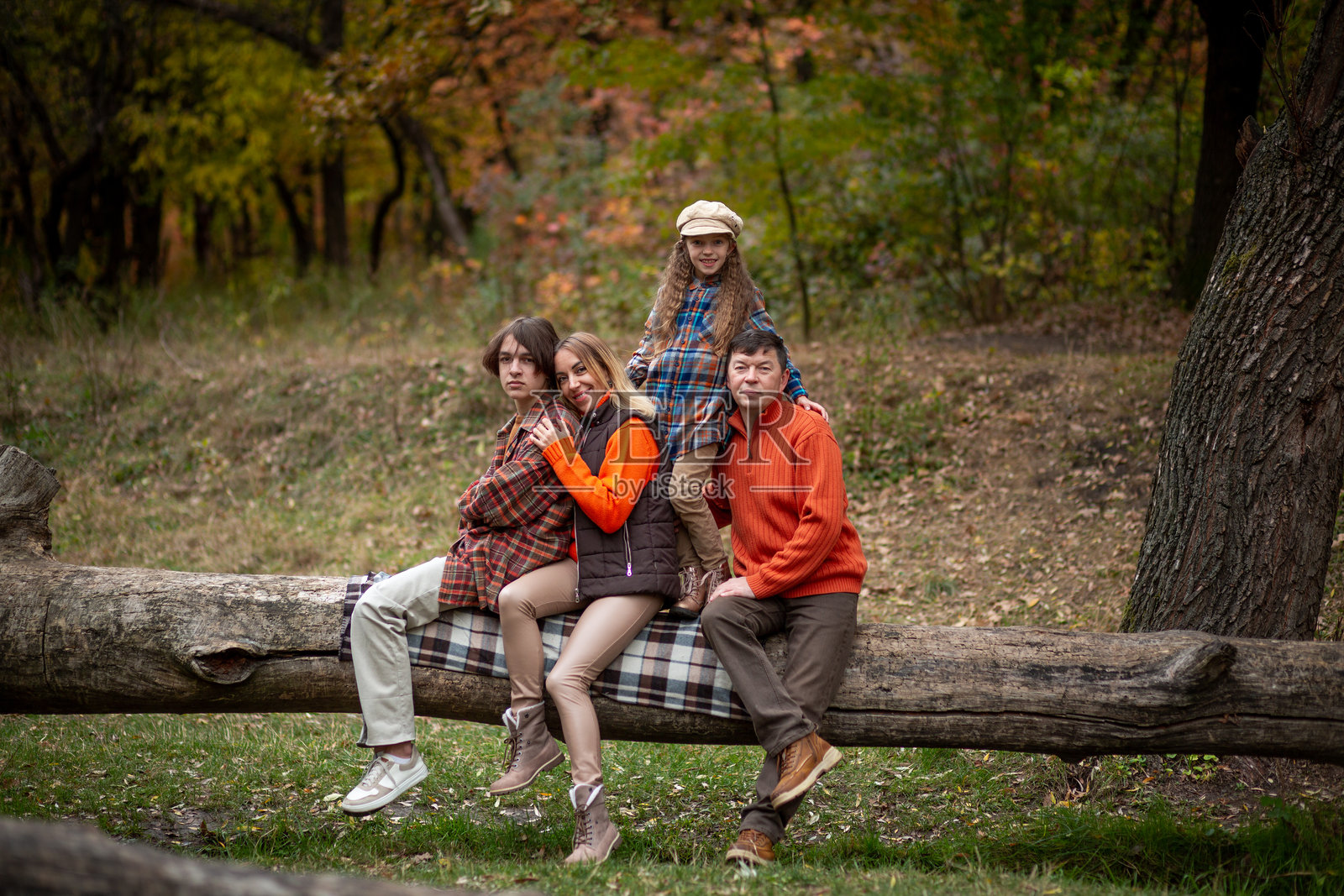 一家四口 - 妈妈、爸爸、女儿和儿子在秋天的公园里玩得很开心照片摄影图片