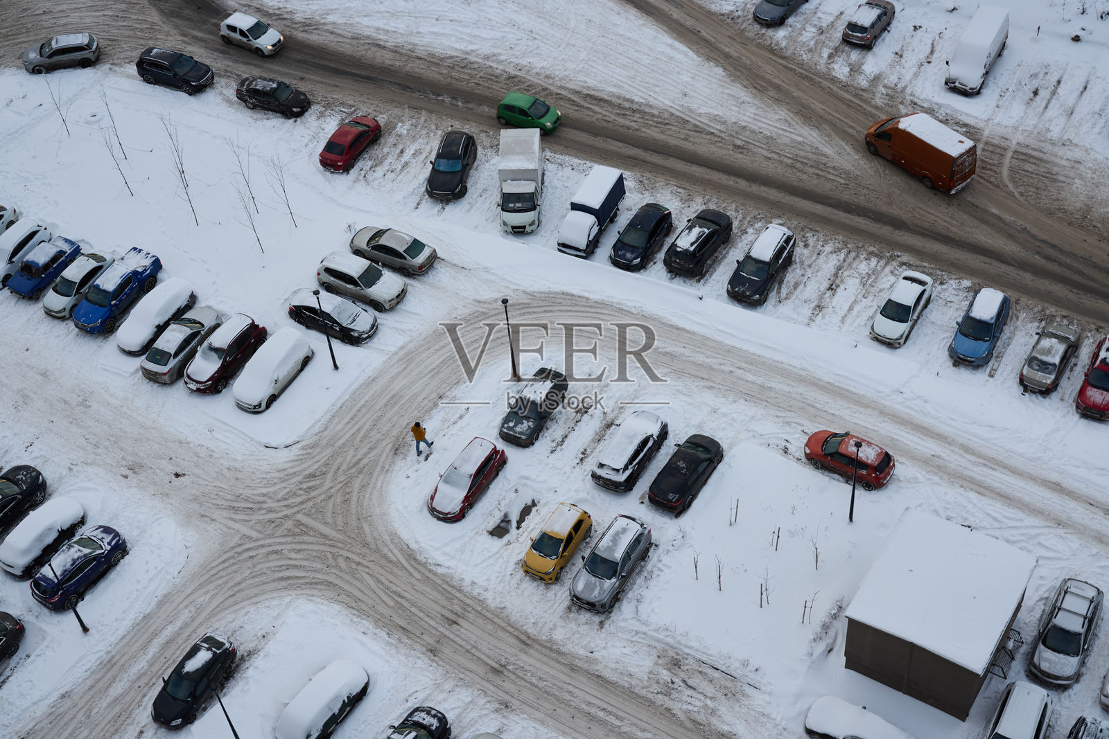 冬季寒冷季节的雪覆盖停车场鸟瞰图，展示了车辆。照片摄影图片