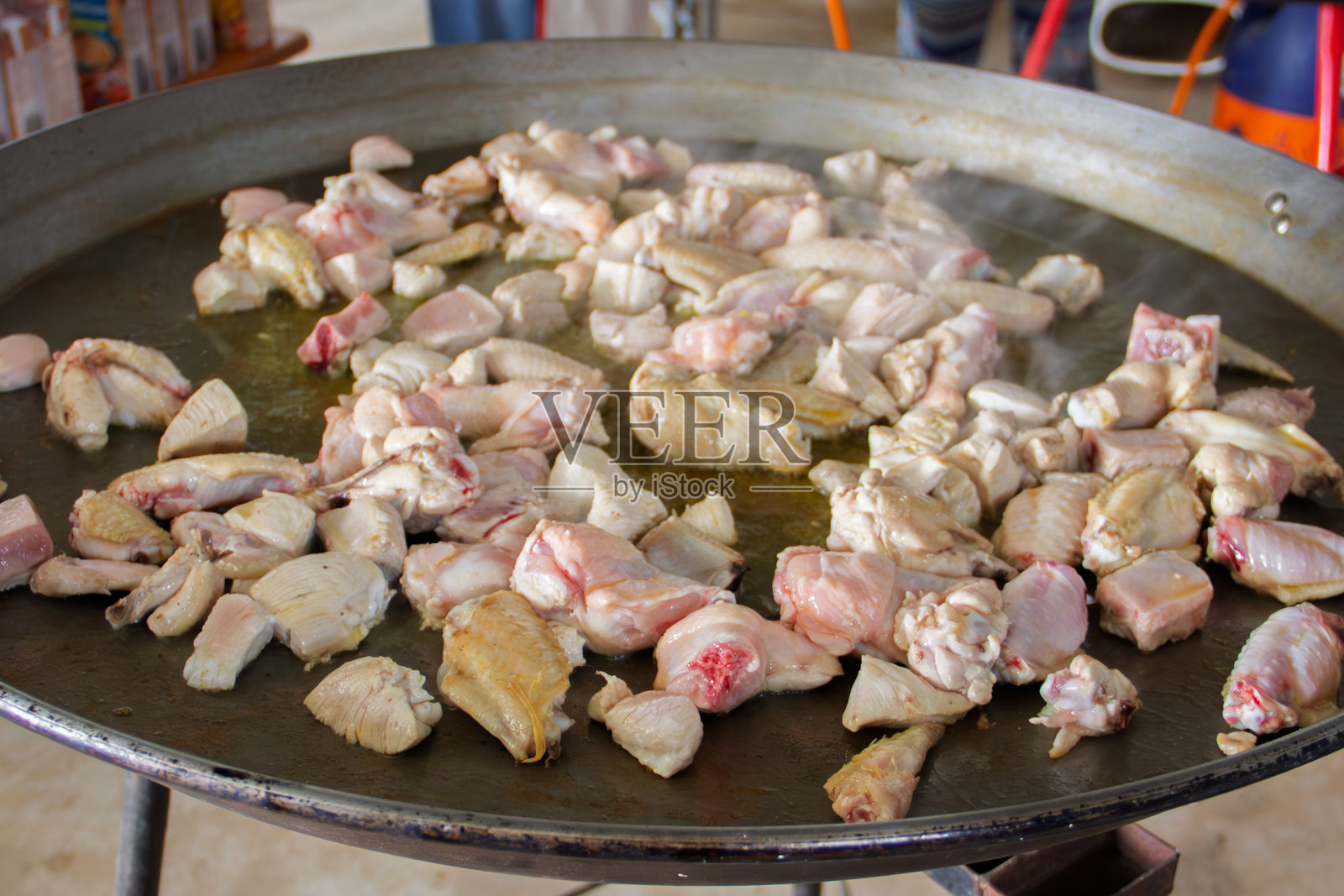 在大海鲜饭锅中烹饪鸡肉，准备餐点。照片摄影图片