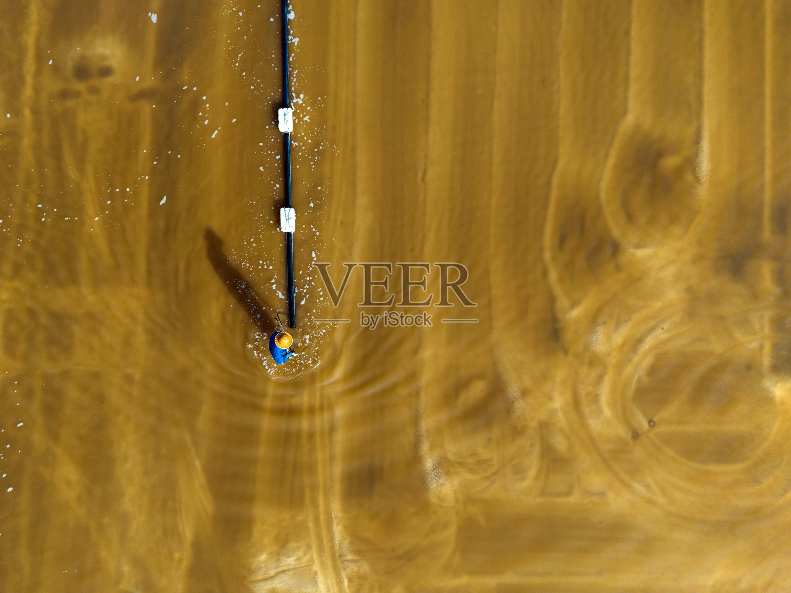 工人在盐田工作，盐场工人在盐田中生产盐。照片摄影图片