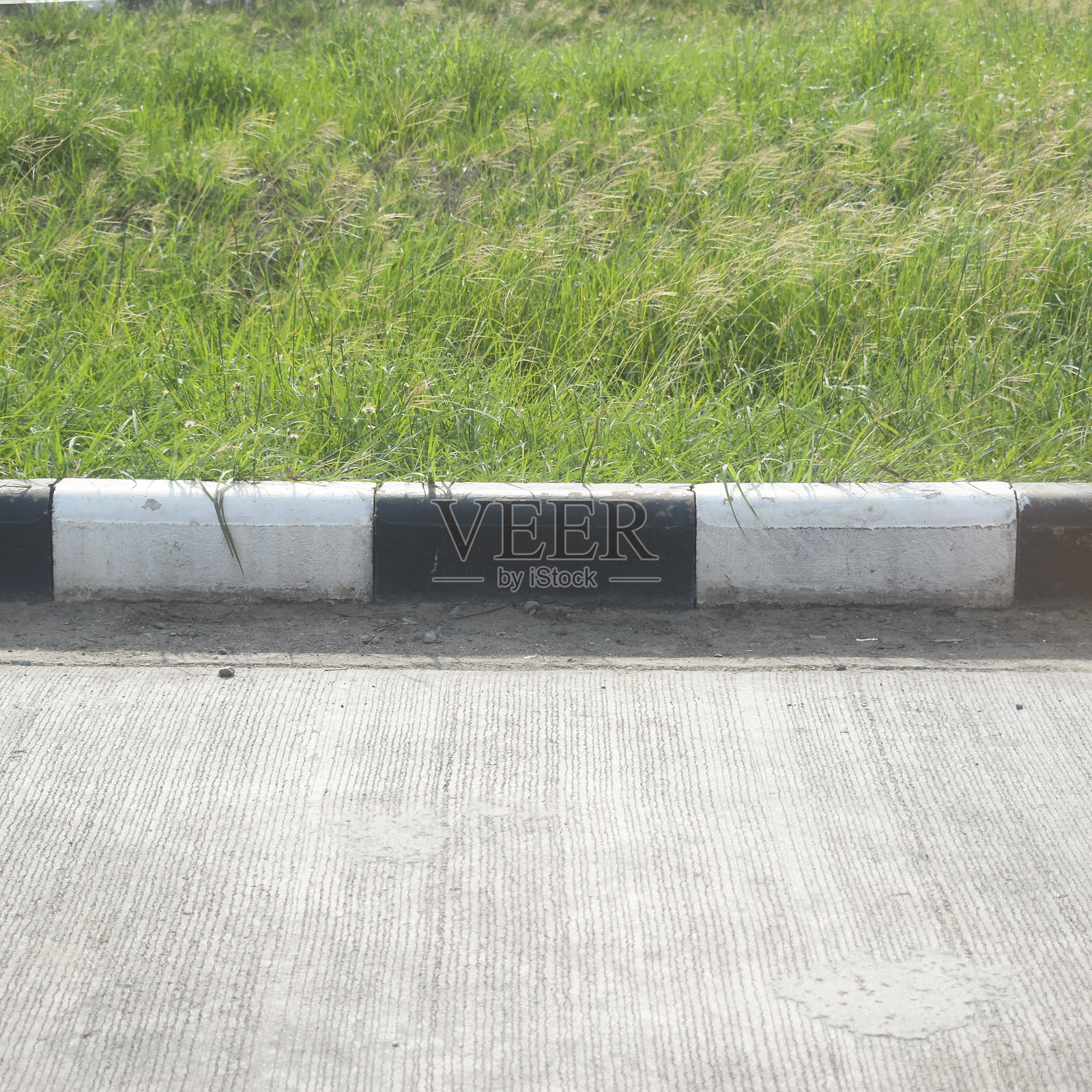 黑白色路缘水泥纹理与绿色草坪照片摄影图片