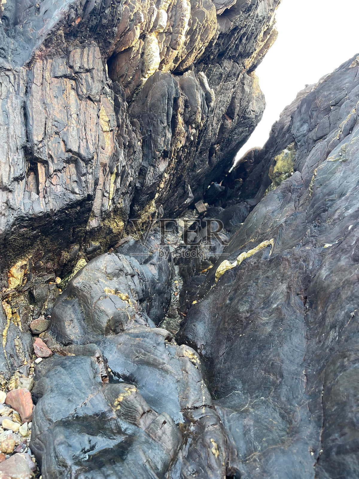 自然破碎岩石的纹理和图案，以及海水随时间造成的侵蚀。照片摄影图片