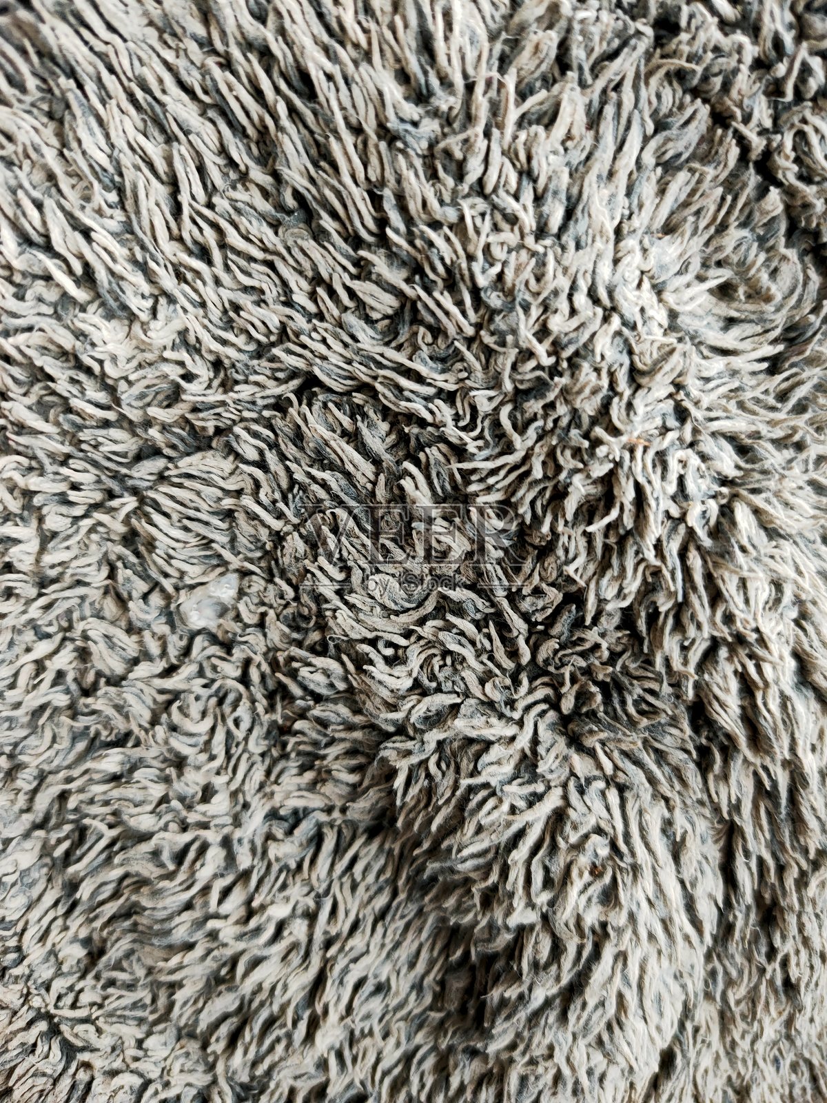 特写镜头展示了一块柔软、有质感的灰色人造毛皮地毯。照片摄影图片