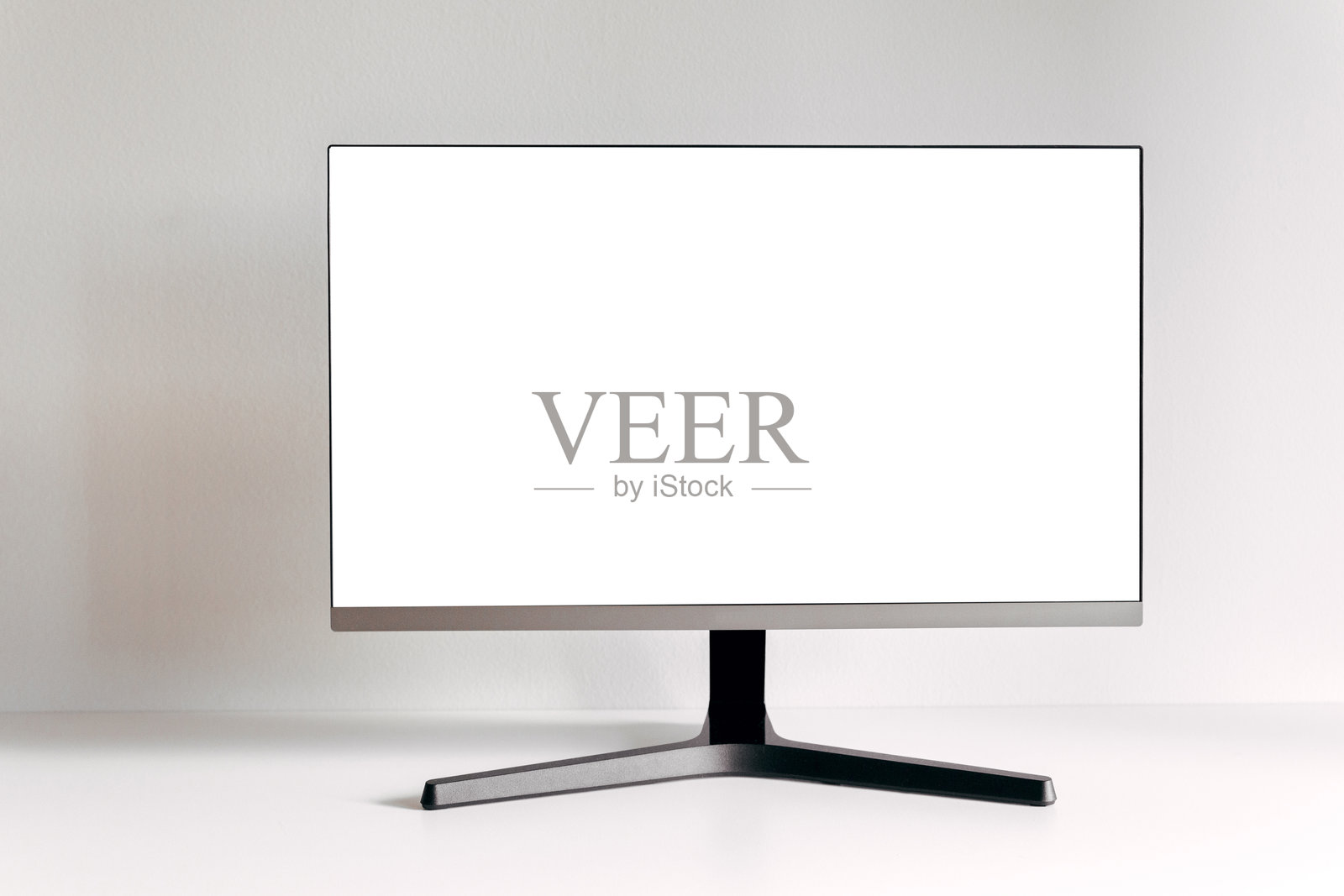 白色桌子上的黑色电脑显示器。设计模板的模拟图。时尚的极简主义室内。灰色背景。照片摄影图片