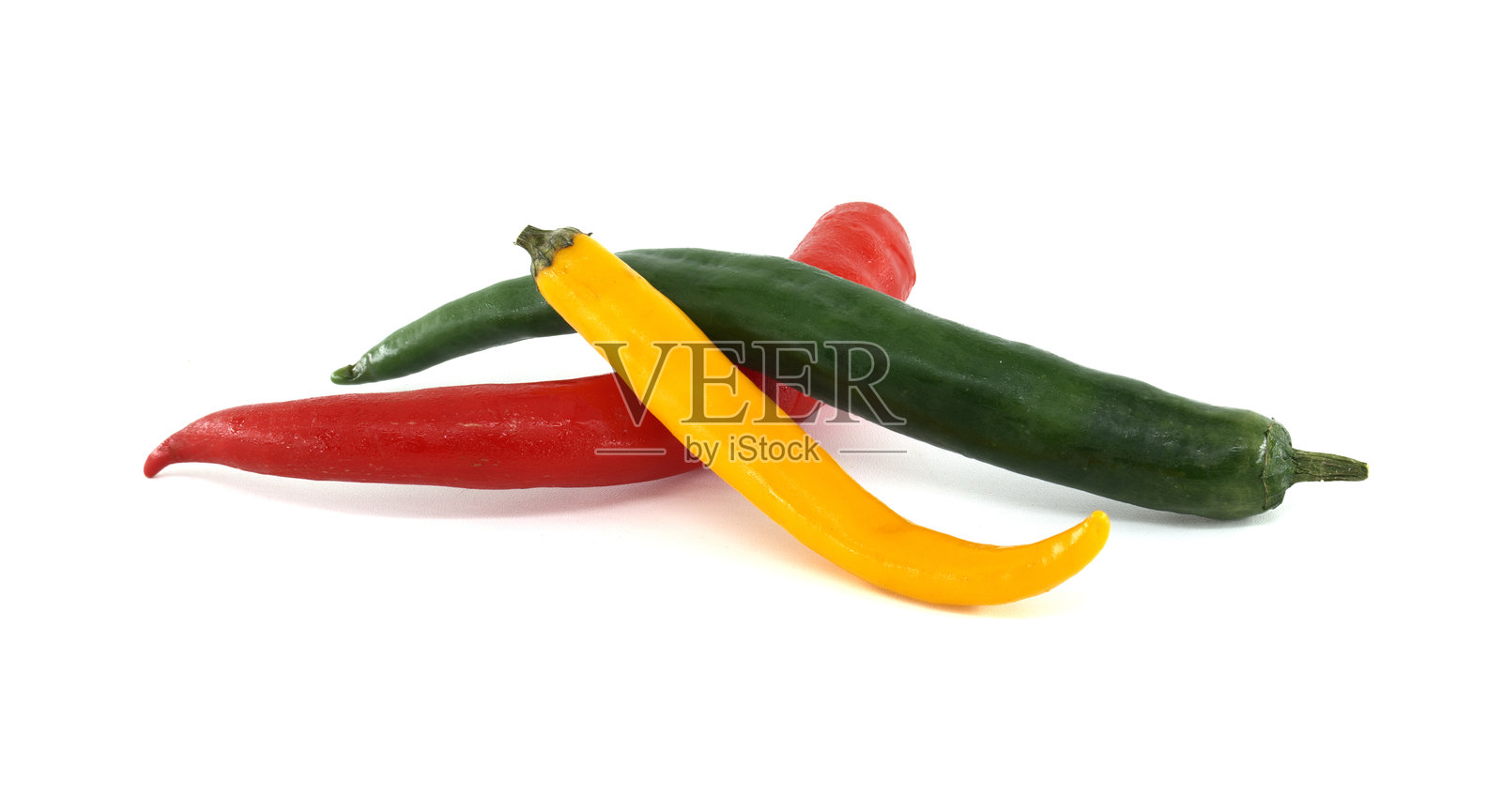 红色、绿色和黄色的辣椒在白色背景上形成一个色彩斑斓的三重奏照片摄影图片