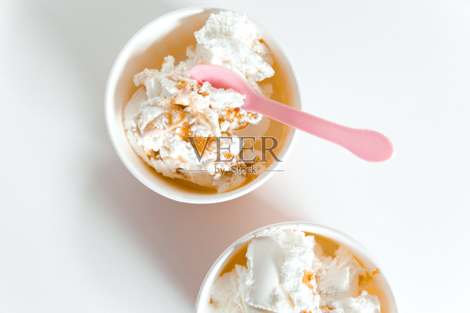 冰淇淋盒子和可爱的粉色勺子。白色背景。俯视图照片摄影图片