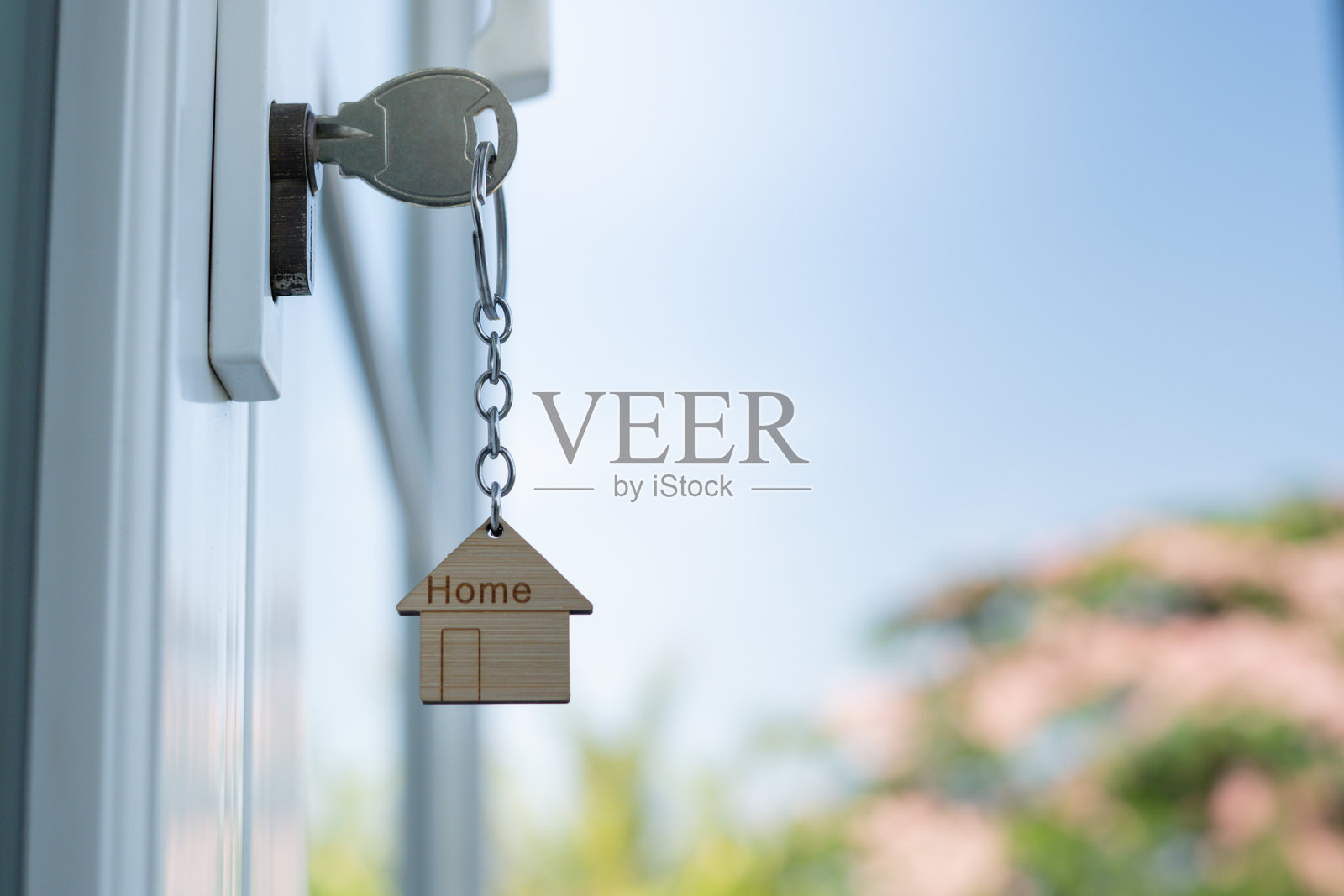 房东的钥匙插在门上，用于打开房子。二手房出租和出售。钥匙链在风中摇曳。新房的抵押贷款，购买、出售、翻新、投资、业主、房地产。照片摄影图片