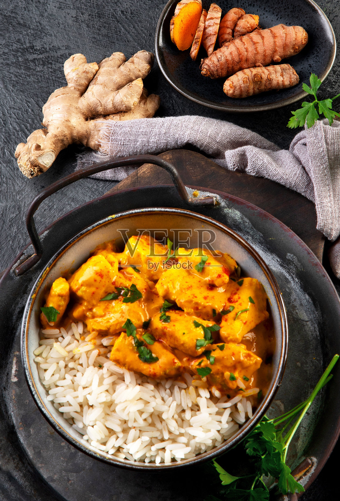 印度黄油鸡咖喱配香米，背景为深色。照片摄影图片